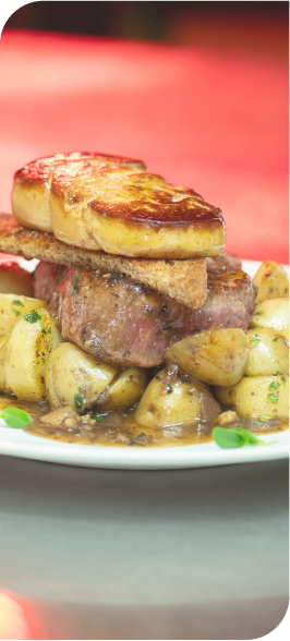 Plat gastronomique composé d’un filet de bœuf tendre surmonté d’un foie gras poêlé, servi avec pommes de terre fondantes.