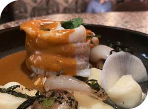 Filet de poisson délicatement roulé, nappé d’une sauce onctueuse, accompagné de légumes de saison.